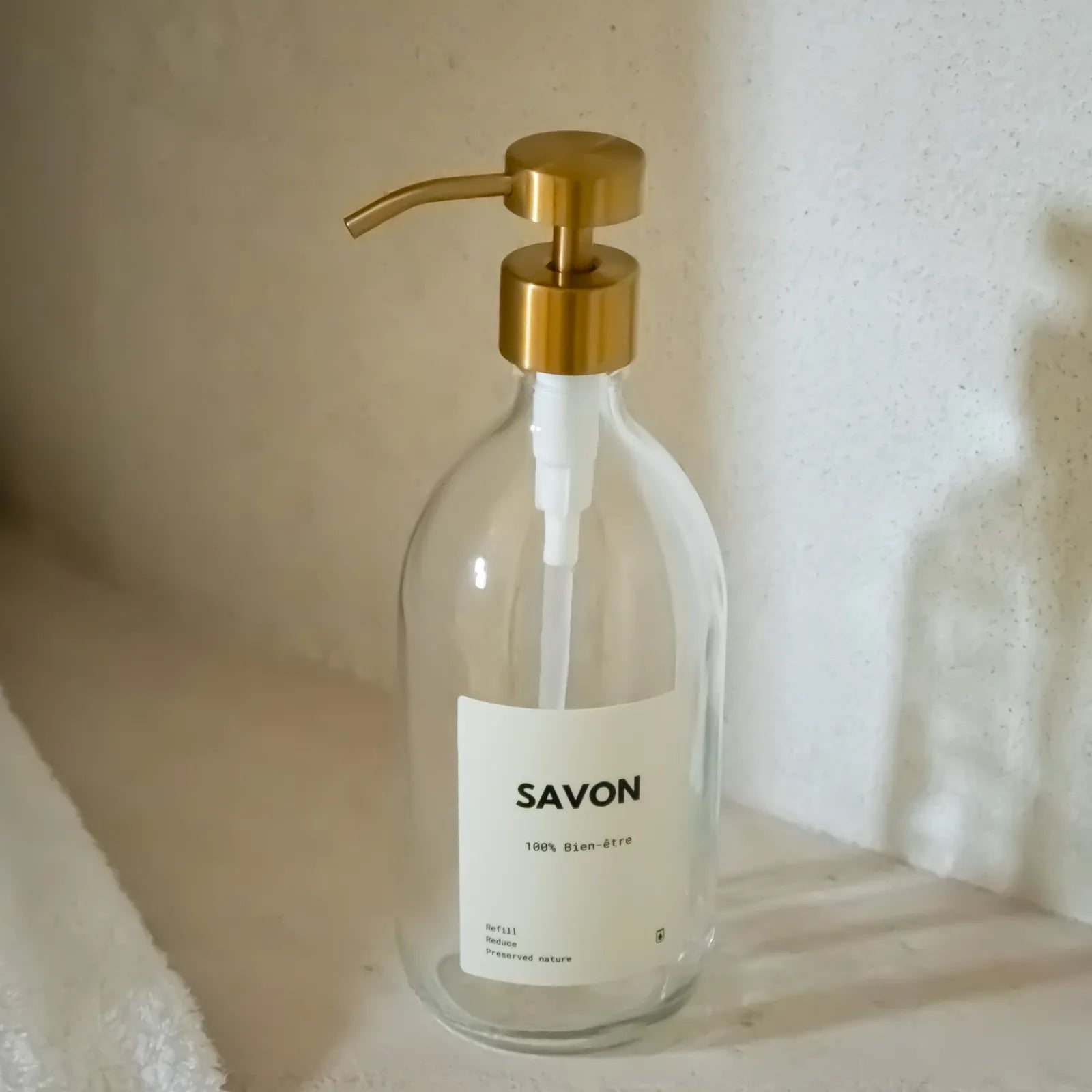 Distributeur de savon en verre transparent de 500 mL avec pompe doseuse inox doré et étiquette savon